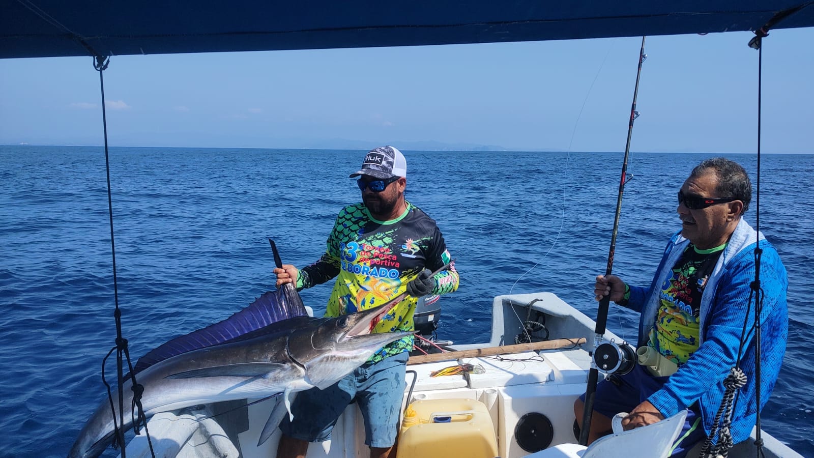 Two anglers with a dorado catch on the boat in Barra de Navidad